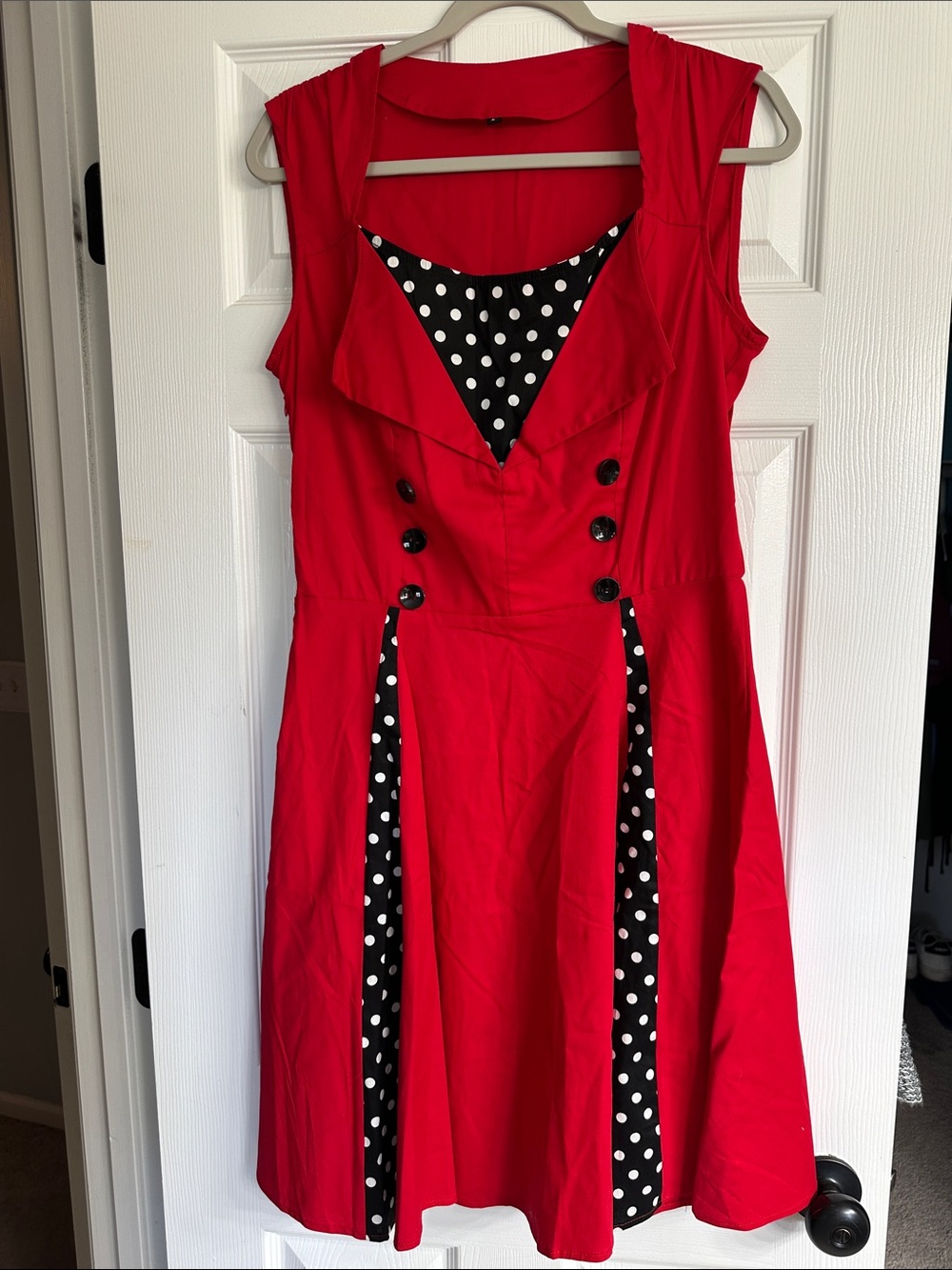 Red sleeveless dress with black and white polkadot accents.